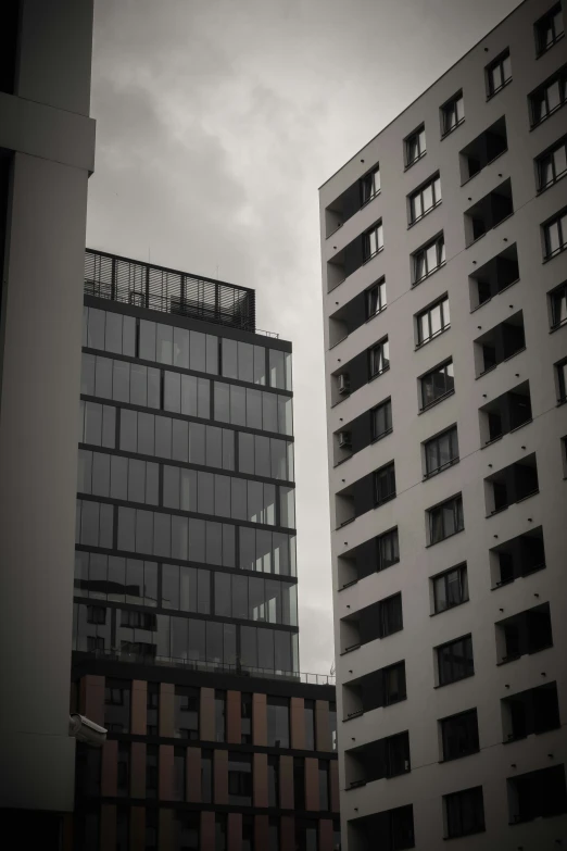 a black and white po of two buildings with some balconies on each floor