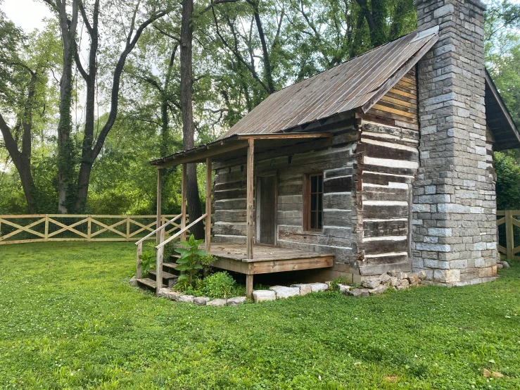 an old rustic log cabin sits on the side of a road