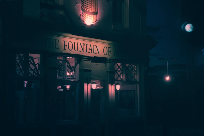 illuminated building sign above dark door at night