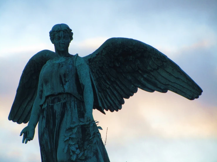 a statue is pictured against a sunset sky