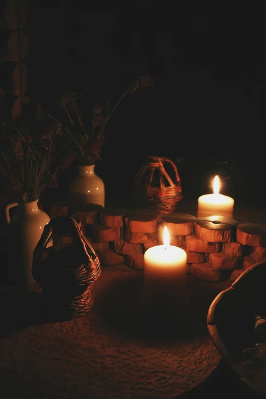 a close up of two lit candles near rocks