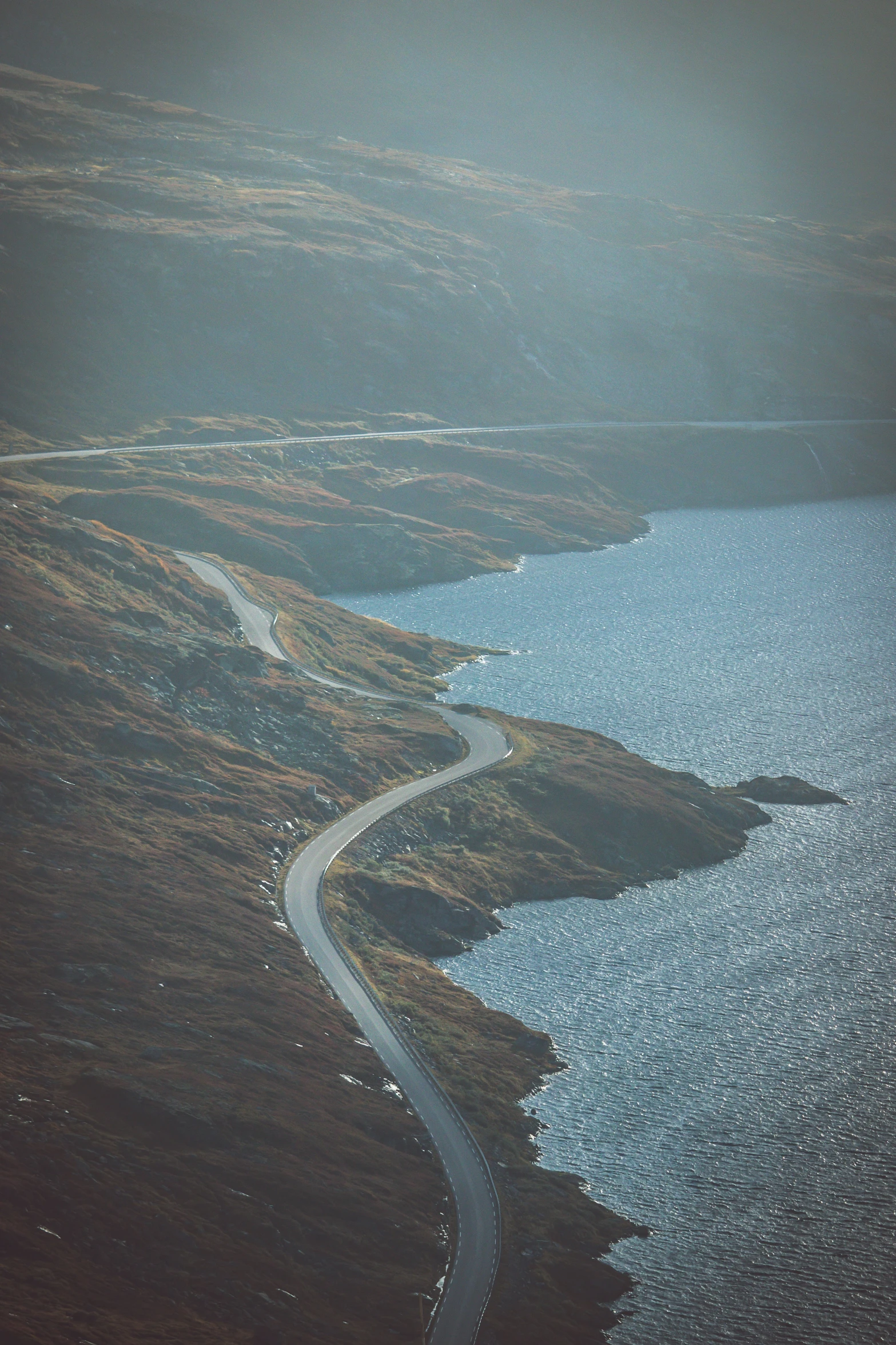 a winding road winding between two water ways