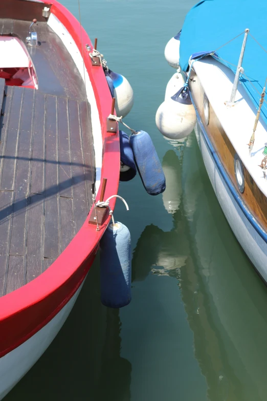 two boats are sitting in water next to each other