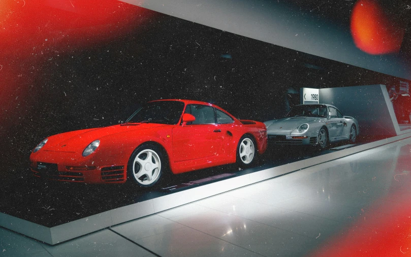 two cars, one red and the other white, in a show room