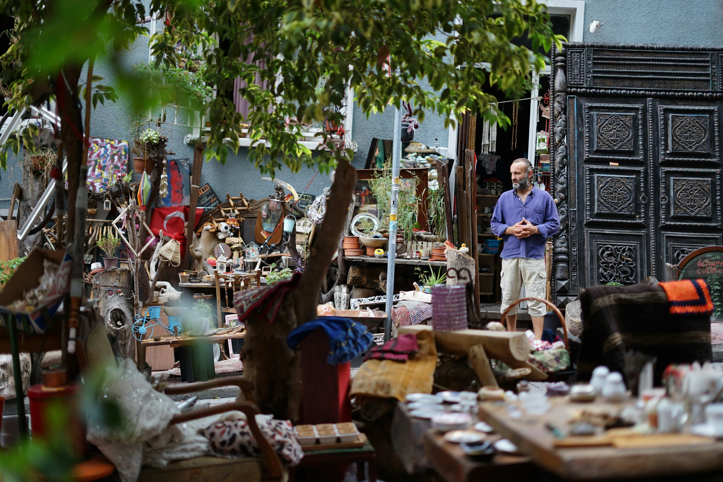 the man stands beside the collection of items for sale