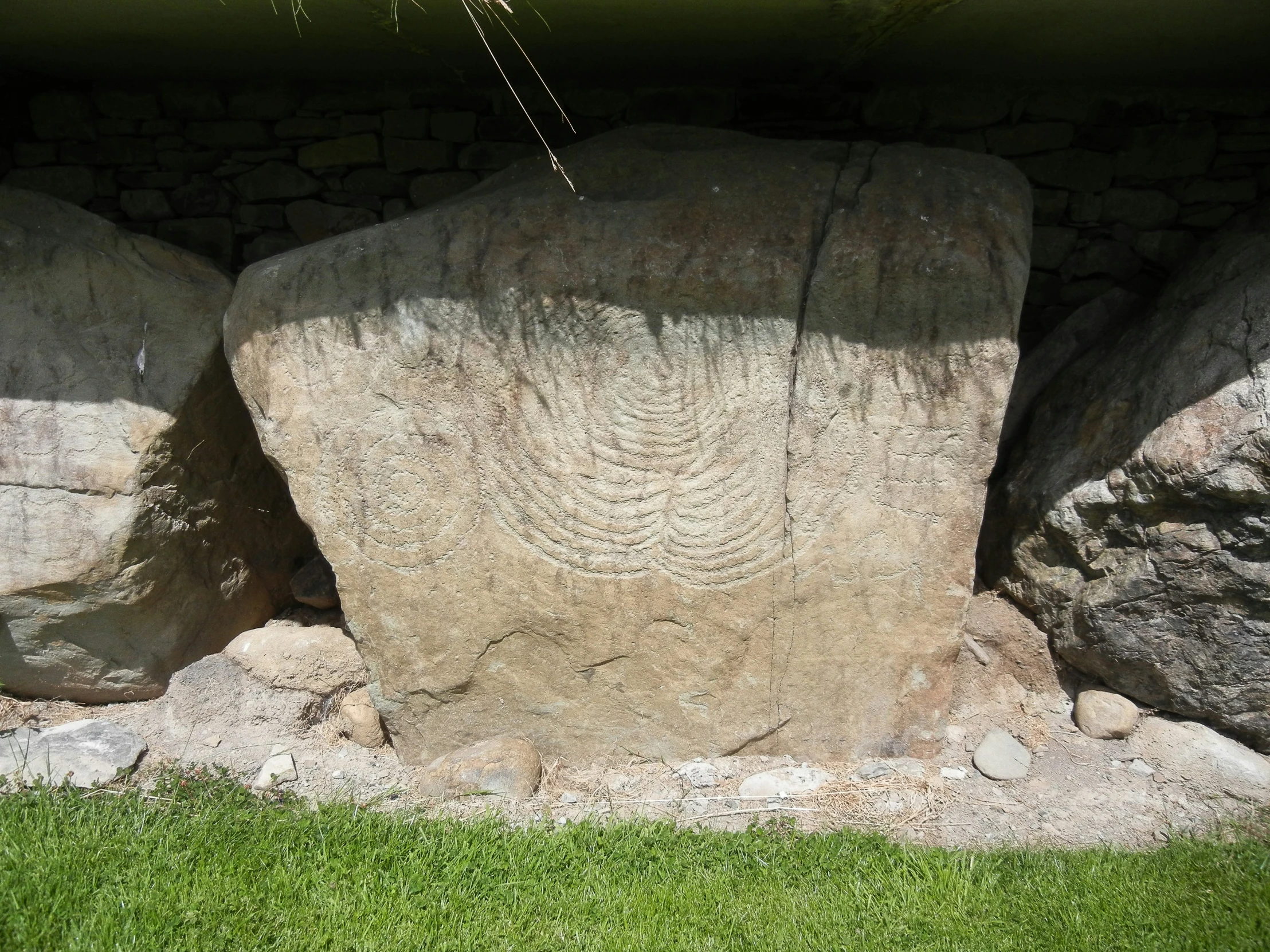 the rock is placed next to the grass near the building