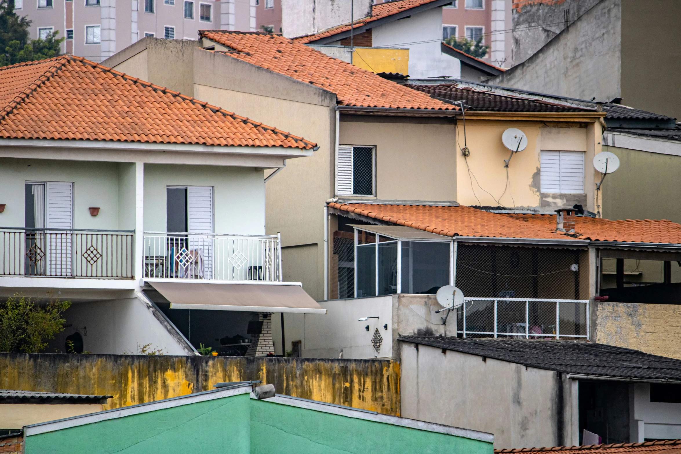 a city with several houses in the foreground and small rooftops