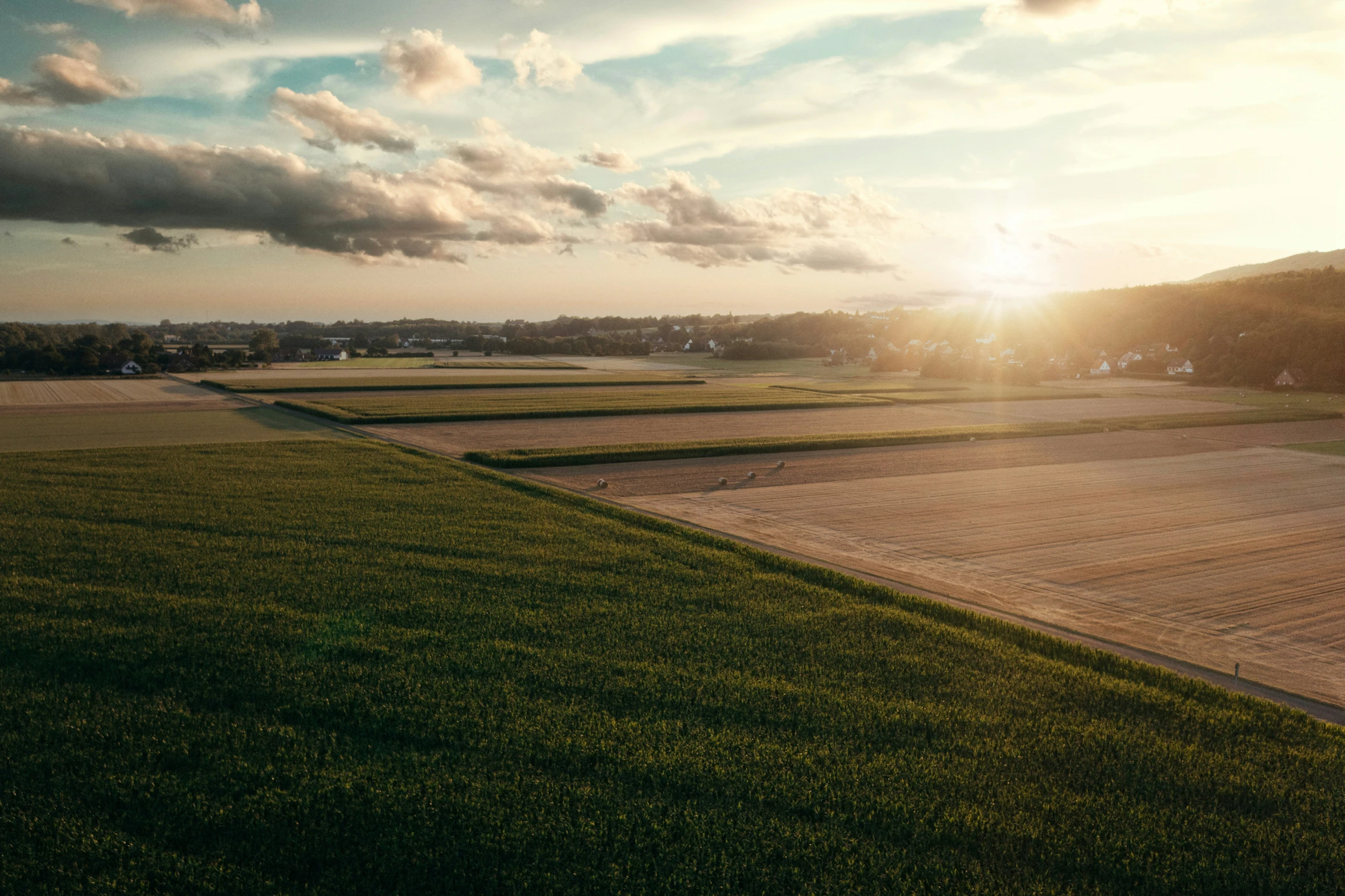 the view of a grassy field in front of the sun