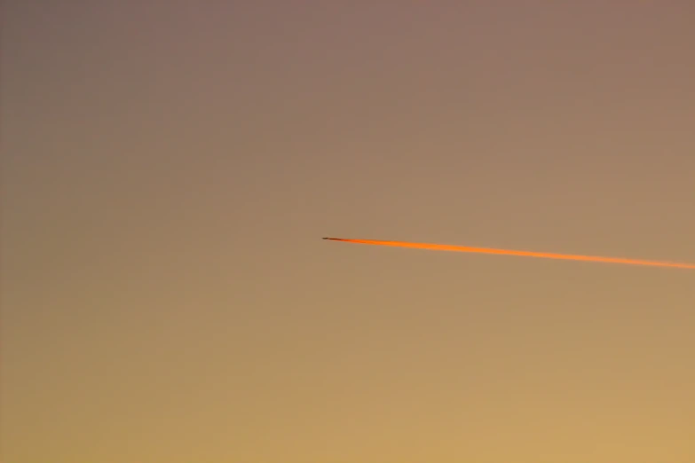 airplane leaving red light from the moon against gray sky