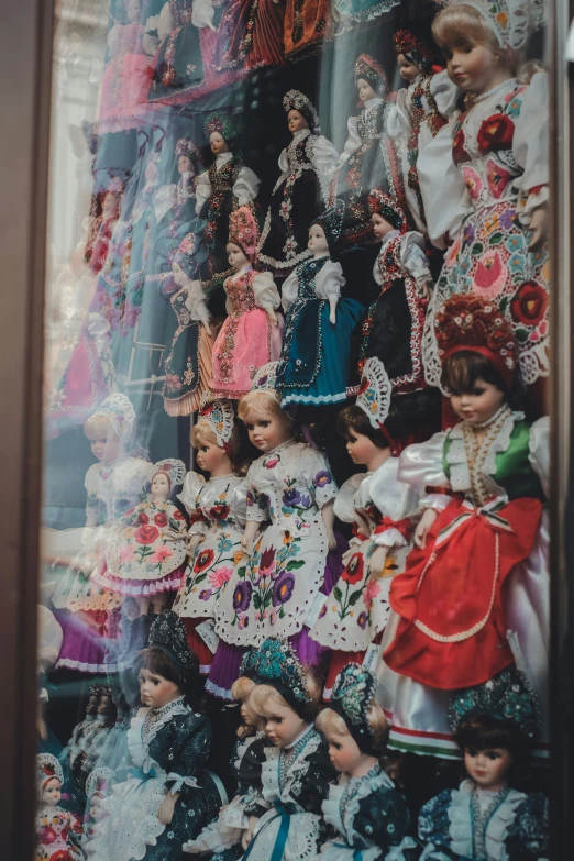 a bunch of dolls hanging on a wall with their picture