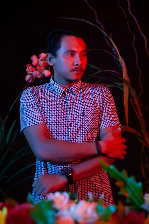 a man standing in front of a bunch of flowers