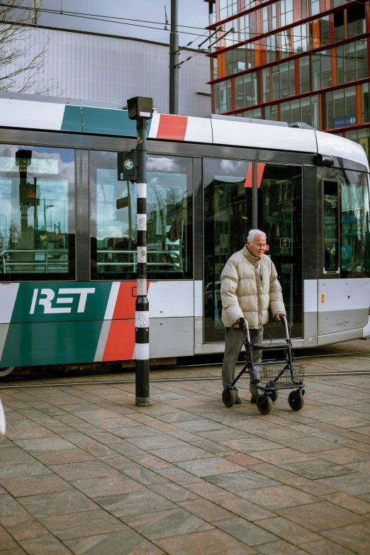 a man in a white jacket pulling a baby stroller by the street