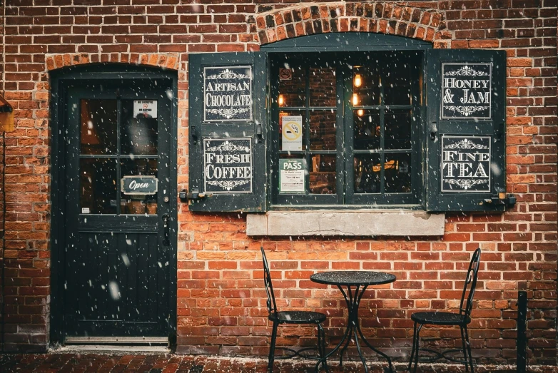 a restaurant sign outside a brick building in the snow