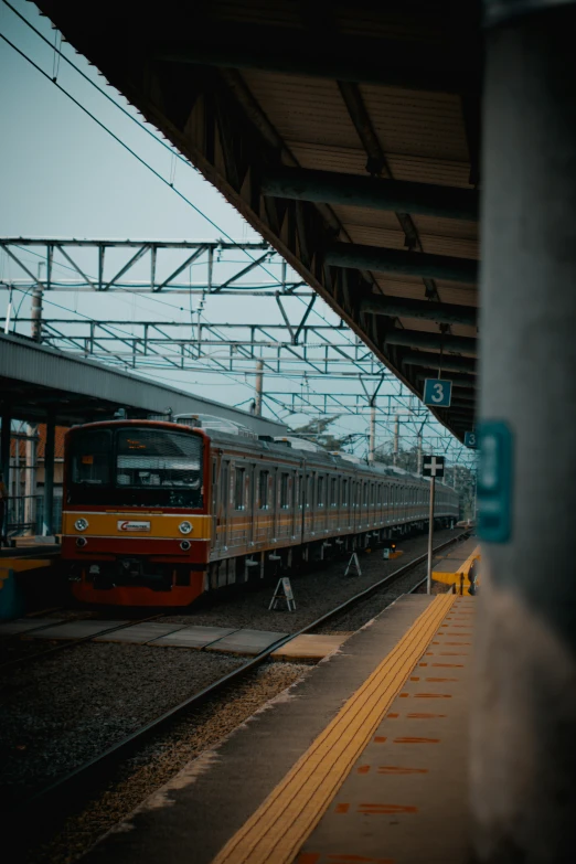 an orange train is pulled into the station