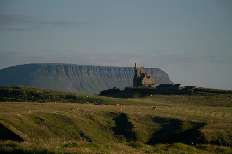 a castle and mountains under a blue sky