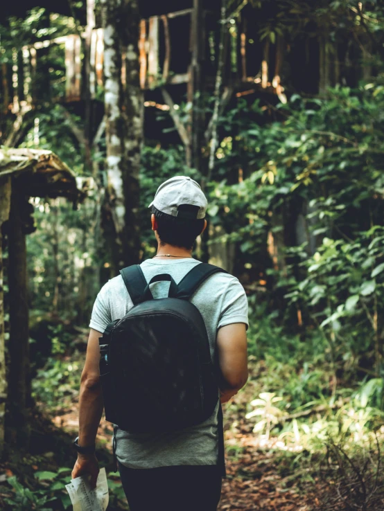 a man wearing a cap and carrying a backpack on a trail