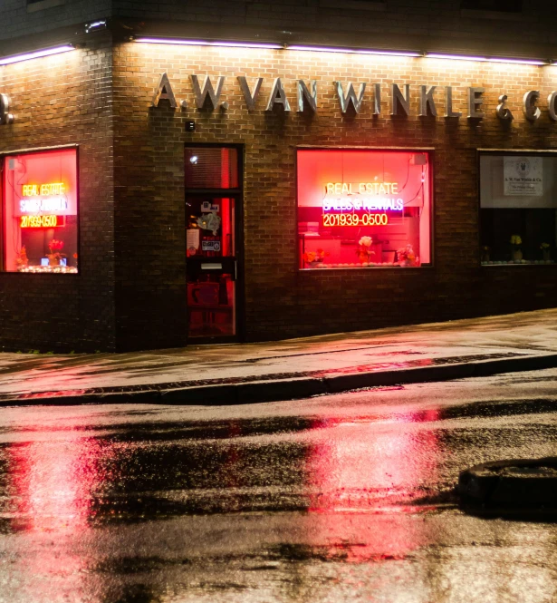 a brick store building with red lights lit up on the windows