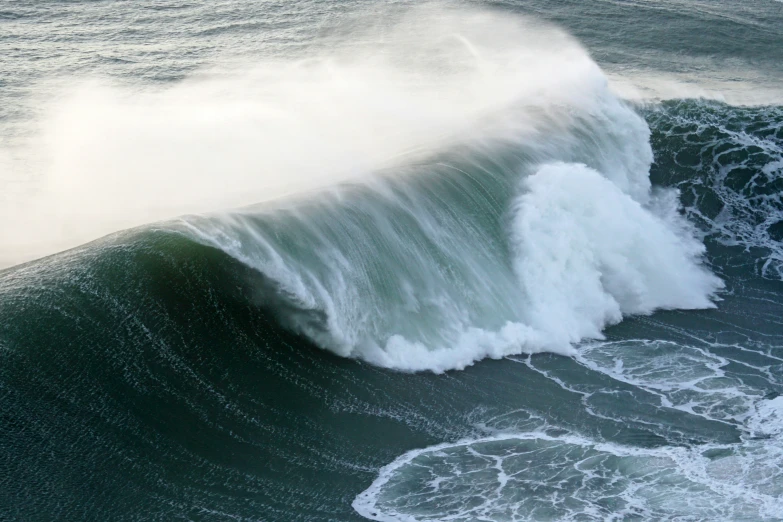 an ocean wave breaks into a large blue wave