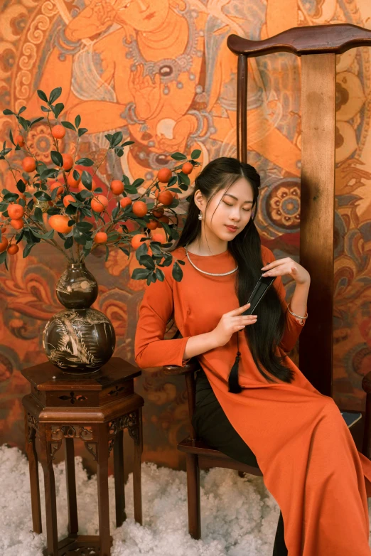 a woman sitting in front of a painting holding a purse