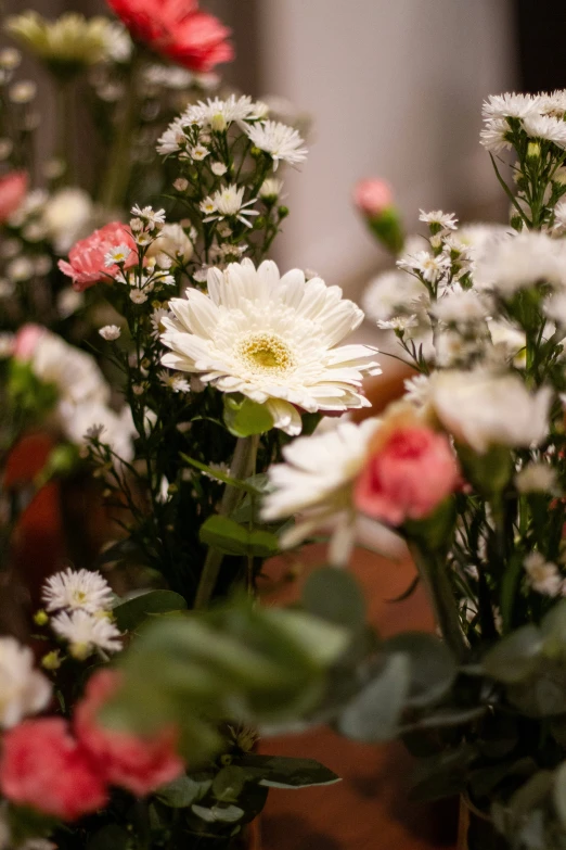 white and red flowers in a vase on a table