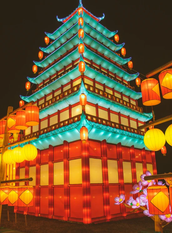 an asian pagoda and lanterns are lit up