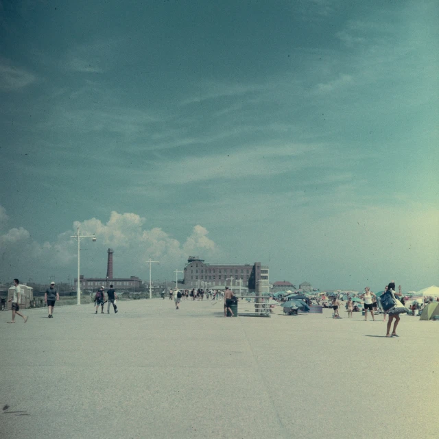 people are standing on the beach playing tennis