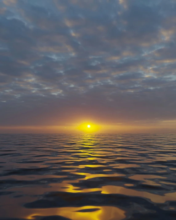 a sun setting over the ocean with clouds above