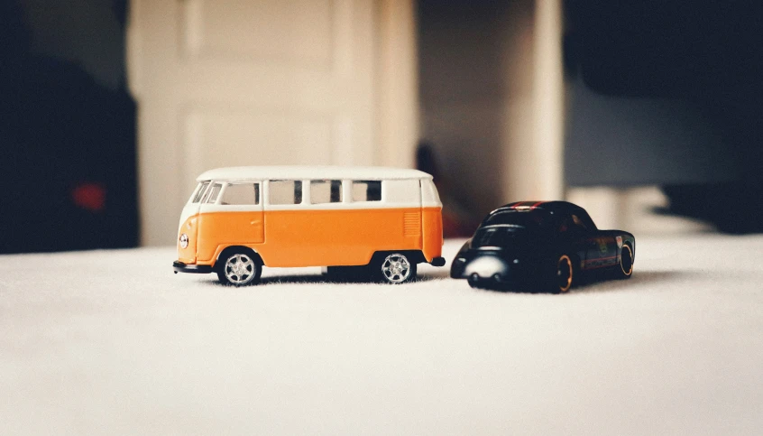 two toy cars sitting side by side on a floor