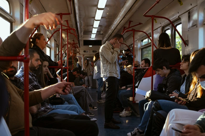 a man standing on a bus while others sit and watch