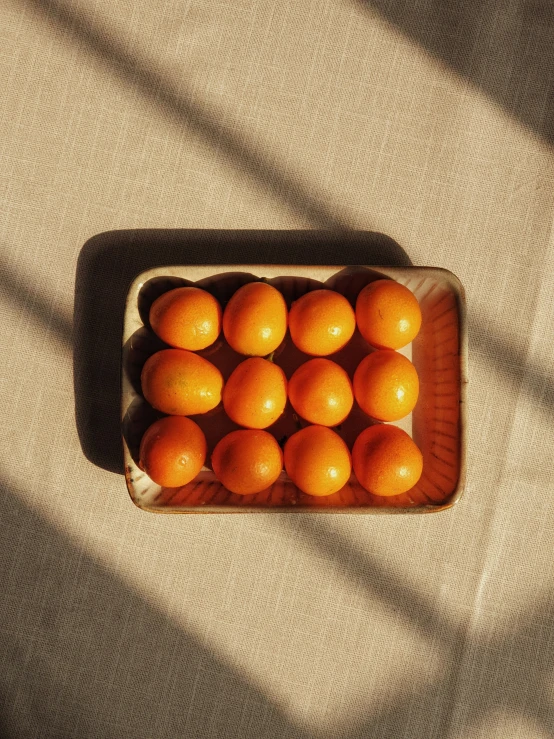 a wooden tray filled with oranges on top of a couch