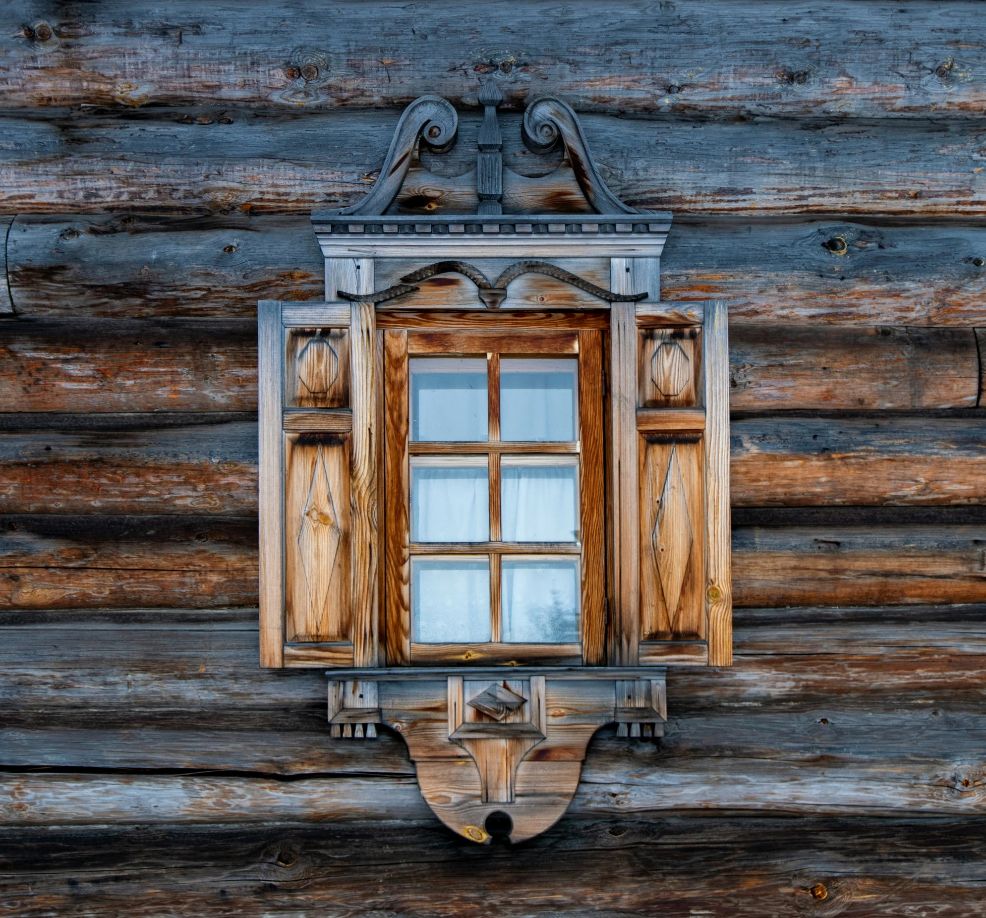 a window on the side of an old log cabin