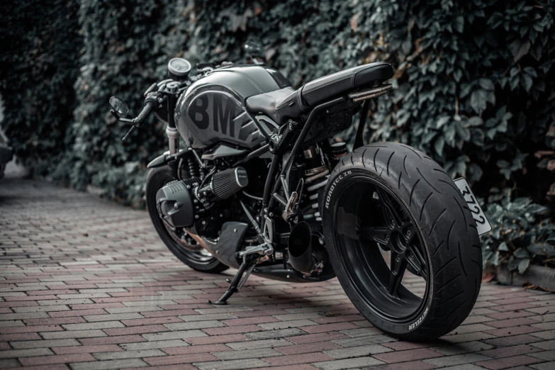 a motorcycle parked on the street near green bushes