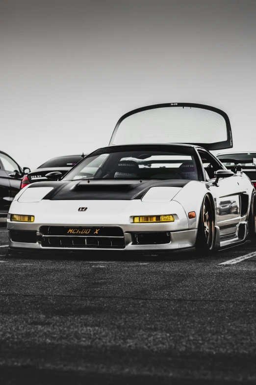 an all white car is parked outside near other cars