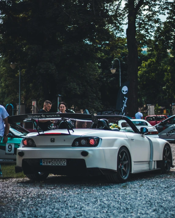 a white sports car on the road surrounded by other cars