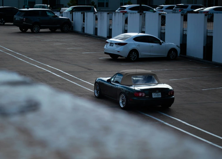 cars drive across the lot towards an empty parking lot