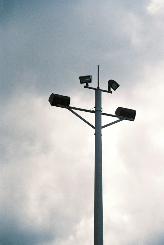 a tall light tower with security cameras on top