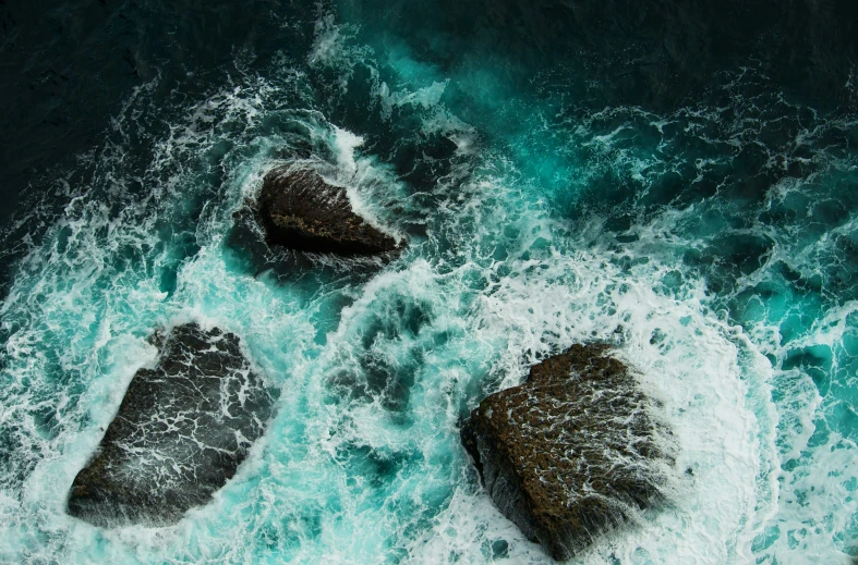 aerial view of two rocks on a large body of water