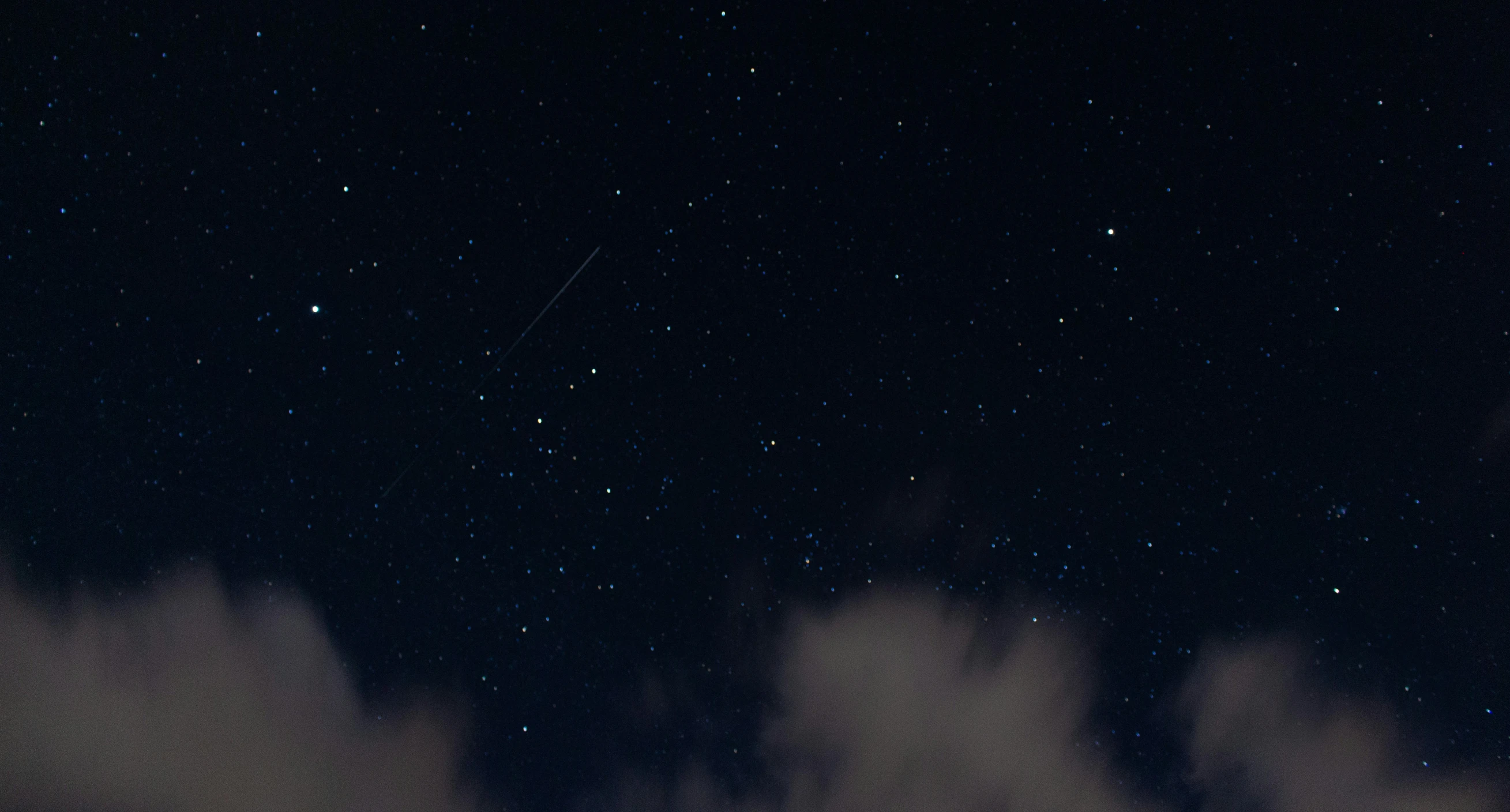 the sky with clouds and a space rocket at night