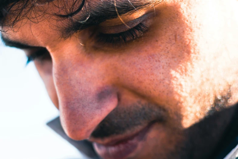 close up of a man with long hair using a cell phone