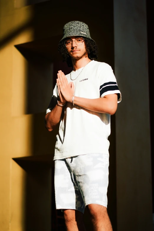 a man wearing sunglasses and a hat while posing