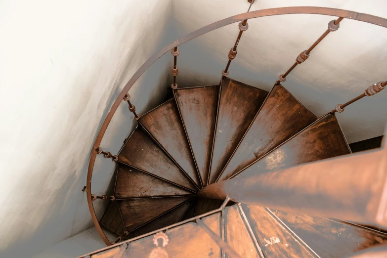 a rusty spiral staircase in a building with lots of steel rails