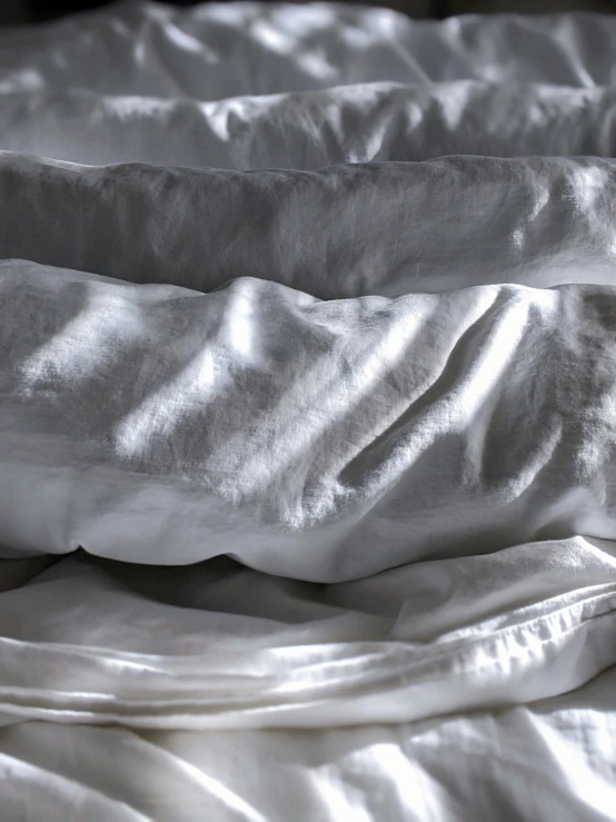 an unmade bed covered with a blanket