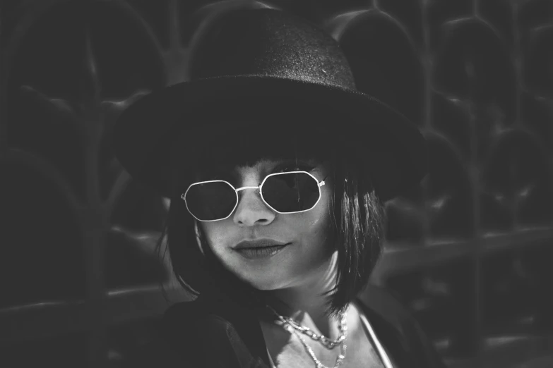 black and white pograph of a woman wearing sunglasses and a hat