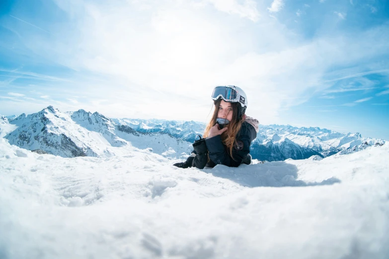 a female is sitting in the snow with snowboards