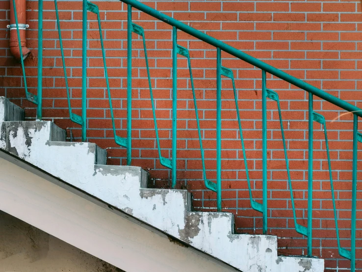 a red brick wall and staircase painted green