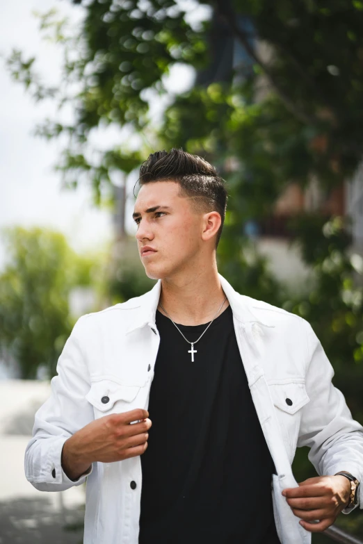 a man with dark shirt and black shirt, wearing a cross necklace