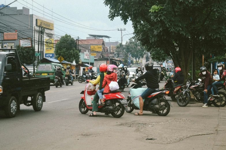 people are driving motorcycles down the street