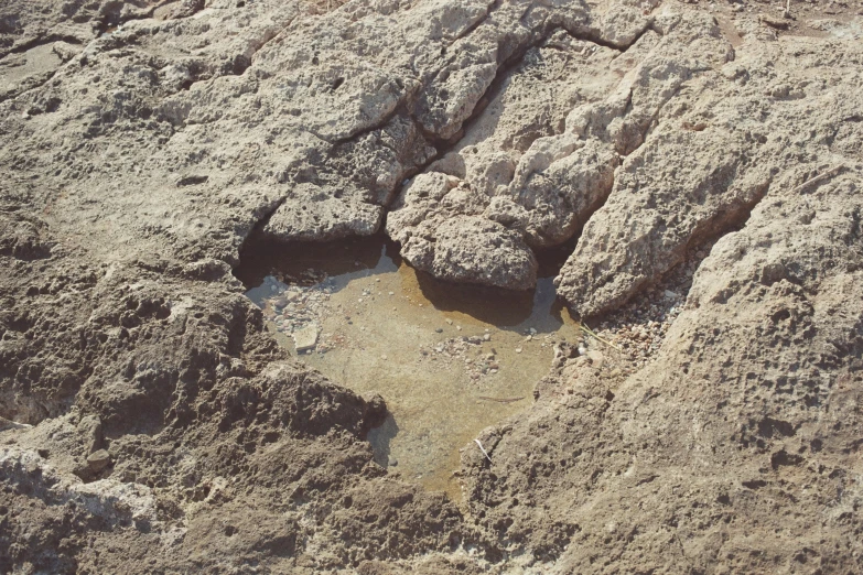 a sandy beach area with various rocks covered in dirt