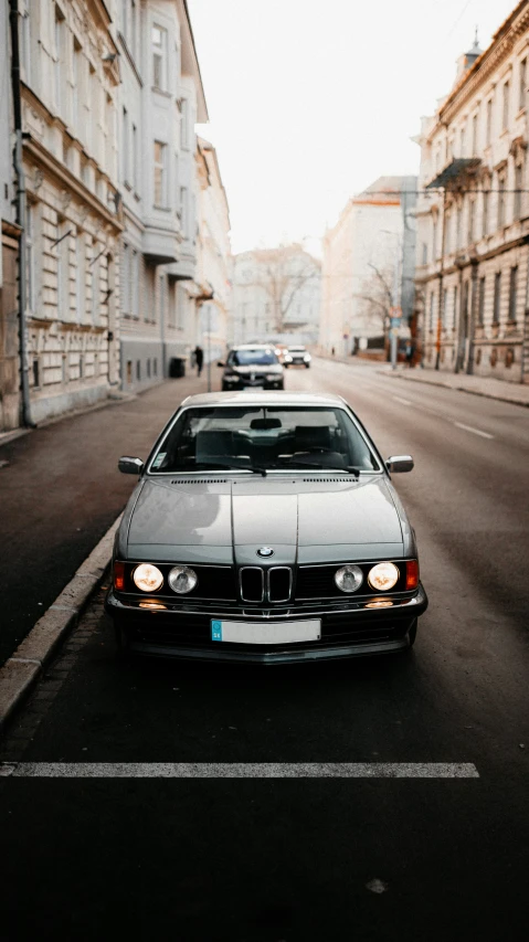 two cars are driving down a dark city street