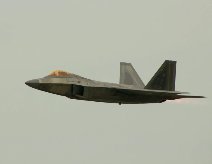 a gray jet flying through a very cloudy sky